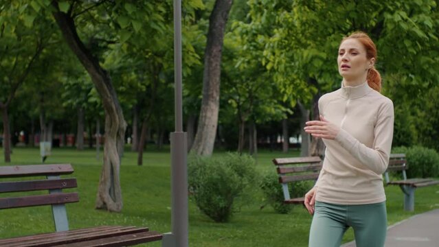 Woman running and jogging in the park feeling sick during workout. Female feels pain on stomach, stops exercise due to stomachache illness. Sickness and healthcare concept.