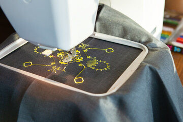 A modern embroidery machine creates an abstract pattern.