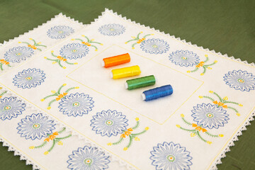 Napkin with embroidery in the form of cornflowers and spools of thread.