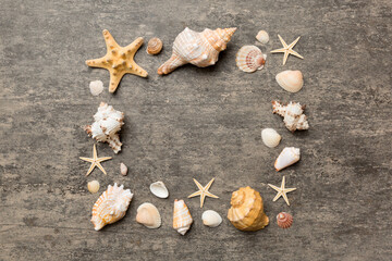 Fototapeta na wymiar Summer time concept on colored background. Seashells from ocean shore in the shape of frame separated with space for text top view