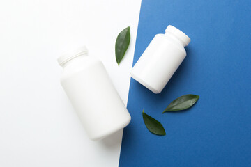 supplement pills with medicine bottle health care and medical top view. Vitamin tablets. Top view mockup bottle for pills and vitamins with green leaves, natural organic bio supplement, copy space