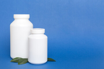 supplement pills with medicine bottle health care and medical top view. Vitamin tablets. Top view mockup bottle for pills and vitamins with green leaves, natural organic bio supplement, copy space