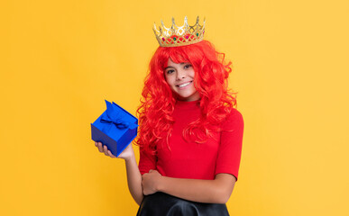 happy child in crown with present box on yellow background