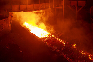 Hot melting pig iron in blast furnace workshop.