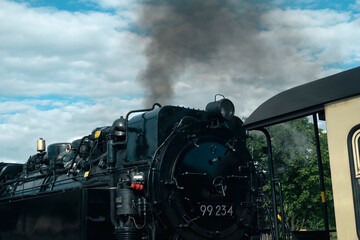 An old steam locomotive throws out clouds of smoke, polluting the atmosphere