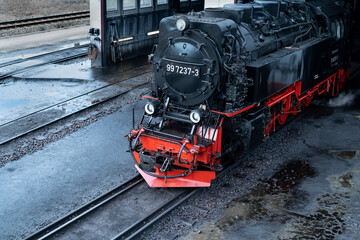 An old steam locomotive leaves the depot for a tourist route