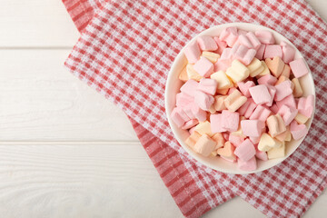 Strawberry marshmallows in a glass bowl on a white textured background with a rustic napkin.Closeup gummies.Snacks and snacks for parties.Spice for coffee and cocoa.Winter food concept.Place for text.