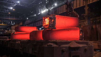 Hot red steel slabs in iron foundry workshop.