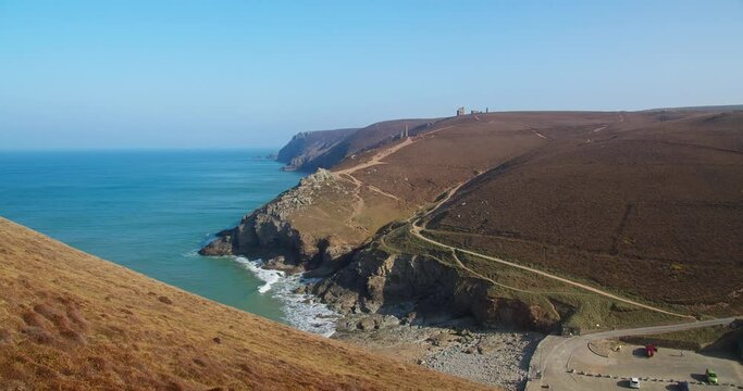 Secluded Beach Of Chapel Porth Between Towering Headlands In North Cornwall Coast In United Kingdom. Aerial Shot