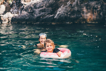 Fototapeta Baby girl swimming with Inflatable ring in the sea. Mother and daughter swimming in the sea. obraz