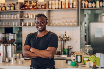 Portrait of an african american male coffee shop owner barista working in a care. - obrazy, fototapety, plakaty