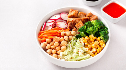Vegan buddha bowl with tofu, colorful vegetables on base of brown rice.