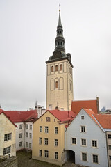 ell tower of Saint Nicholas church above the orange rooftops of Tallinn, Estonia 