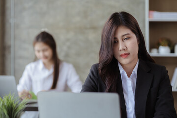 Obraz premium Asian women working in the office, young Asian business women as business executives, founding and running start-up executives, young female business leaders. Startup business concept.