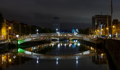 Fototapeta na wymiar Dublin, Ireland. Night view of the famous illuminated Ha Penny Bridge in Dublin, Ireland