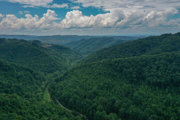 Obraz premium Green Mountain Valley Under Puffy Clouds and Blue Sky