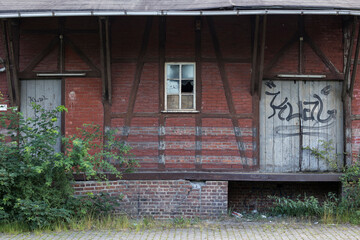 Verfallenes Haus mit kaputtem Fenster und altem Tor