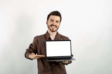 Happy casual man wearing casual clothes posing isolated over white background holding laptop pc computer with blank empty screen.