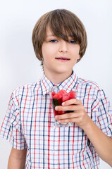 Teenage boy holding watermelon smoothie and smiling