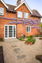 Fototapeta na wymiar House and garden design with patio, French doors, wisteria, UK