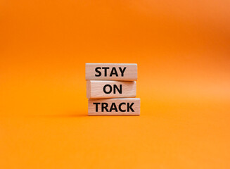 Stay on track symbol. Wooden blocks with words 'Stay on track'. Beautiful orange background. Business and 'Stay on track' concept. Copy space.
