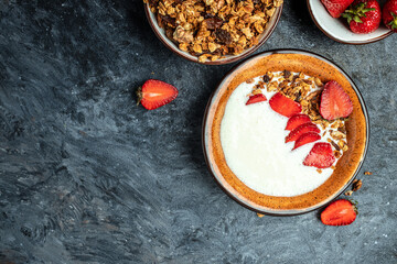 Granola with yogurt, honey and with strawberries on blue wooden table. superfood concept. Healthy, clean eating. Vegan or gluten free diet. top view. place for text