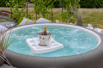Whirlpool for the garden A tray with glasses and a bottle of wine floats in the water