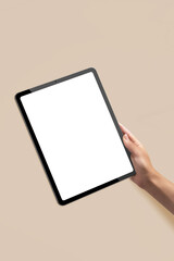 Mockup of new version tablet in trendy thin frame design with white screen with hands on solid beige background for presentation web design, social media design  - obrazy, fototapety, plakaty