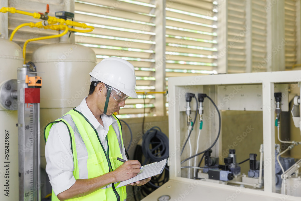 Wall mural electrical engineer holding document board to inspecting the electrical system in a factory, energy 