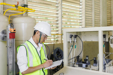 Electrical engineer holding document board to inspecting the electrical system in a factory, energy concept.
