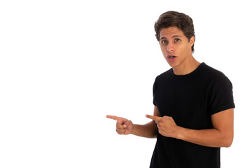 Surprised young man pointing finger away at copy space isolated white background