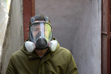 A young guy in a respirator in a bomb shelter.