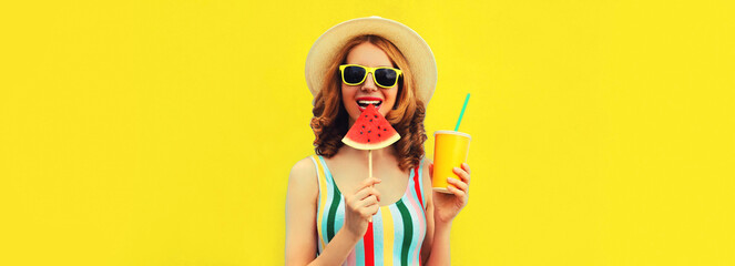 Summer portrait of happy smiling young woman with lollipop or ice cream shaped slice of watermelon and cup of juice wearing straw hat on yellow background, blank copy space for advertising text