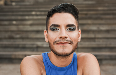 Young man with make up smiling on camera outdoor - obrazy, fototapety, plakaty