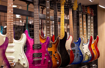Plakat Сolored electric guitars at showcase in music store