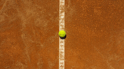Lamas personalizadas de deportes con tu foto  A yellow tennis ball lies on the clay court.