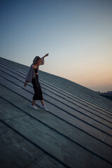 Young woman posing in the roof at sunset, freedom city atmosphere. People, lifestyle, relaxation...