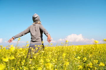 asian woman enjoying nature in a canola flower field