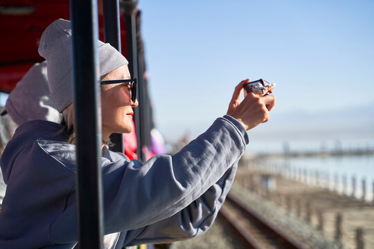 asian woman tourist taking a picture using cellphone on a sightseeing train