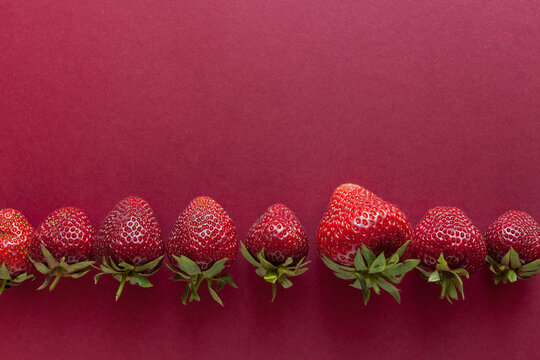 Strawberries on a red background. View from above. Food concept. Copy space