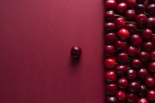 Ripe cherry berries on a red background with space for text. Top view. Food concept. Copy space