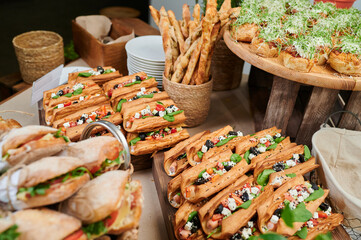 Sausage sandwich with basil leaves at the catering of the event