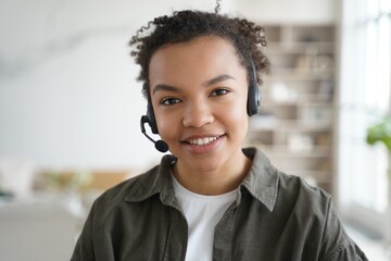 Biracial girl student in headset learning online, looking at camera. Distance education, elearning