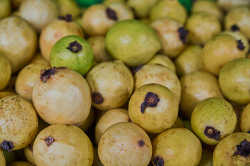 Juicy guavas placed on a shelf for sale inside a market
