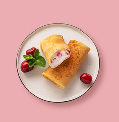 Delicious homemade pancakes or crepes  with cottage cheese and fresh cherries on a pink background. Concept healthy  food. Top view
