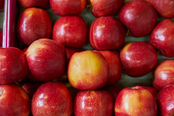 Stacked apples placed on a shelf for sale within a market