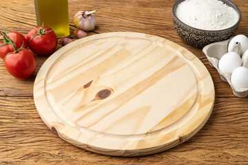Empty pizza wooden board with tomatoes, eggs and flour. Pizza negative space