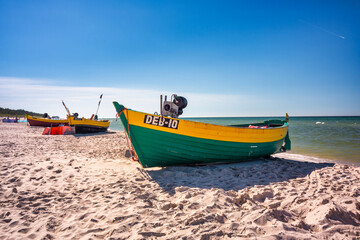 Fototapeta na wymiar Fishing boat on the sunny Baltic Sea beach in Debki. Poland