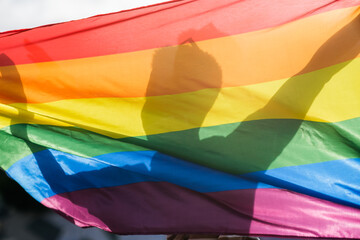 Shadow of an unrecognizable person holding the lgtbi flag