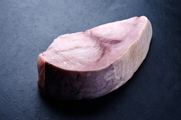 Rohes Schwerfisch Steak angeboten als close-up auf einem schwarzen Board